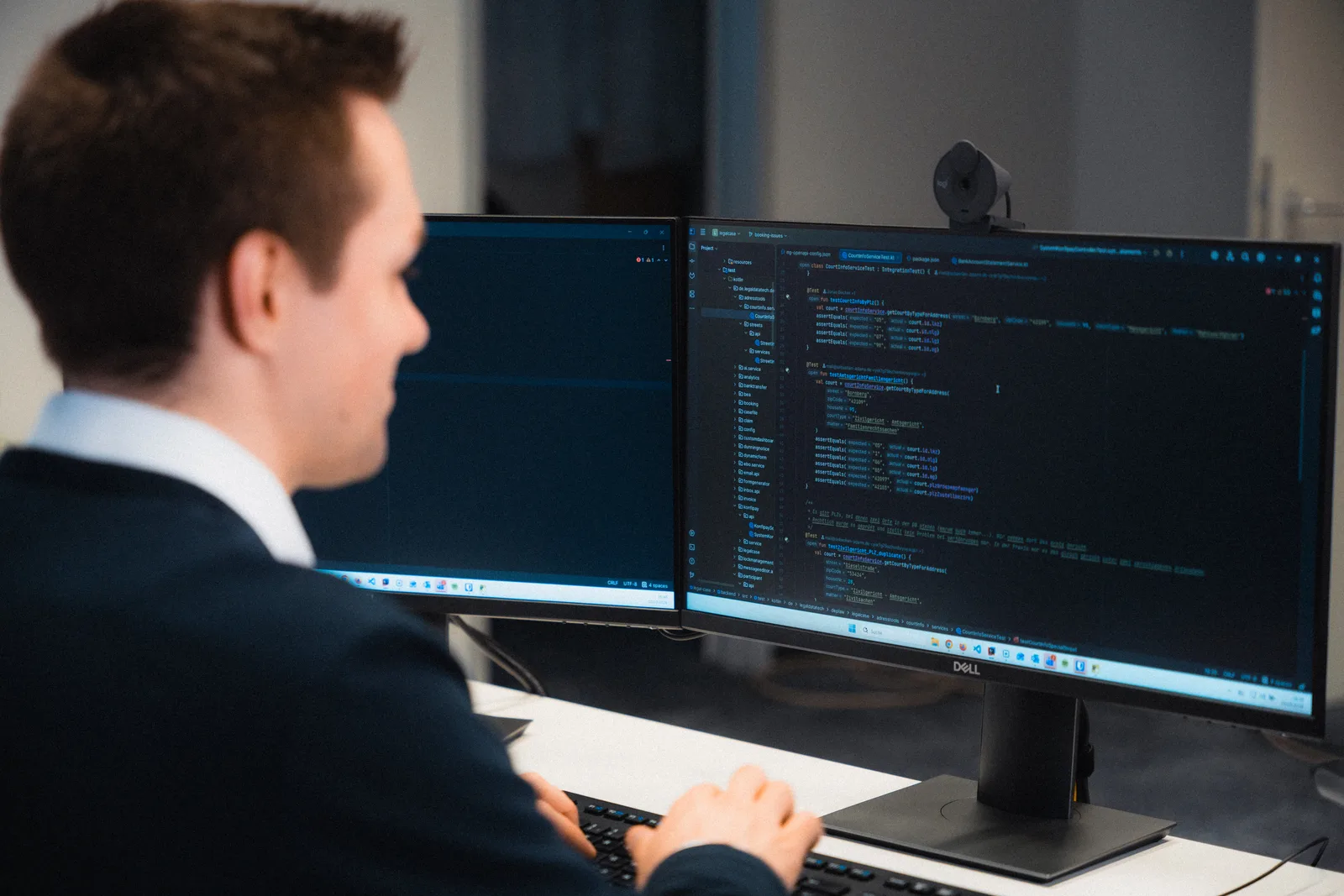 Entwickler von Legal Data Technology bei der Arbeit am DEPLAW-Quellcode auf zwei Bildschirmen