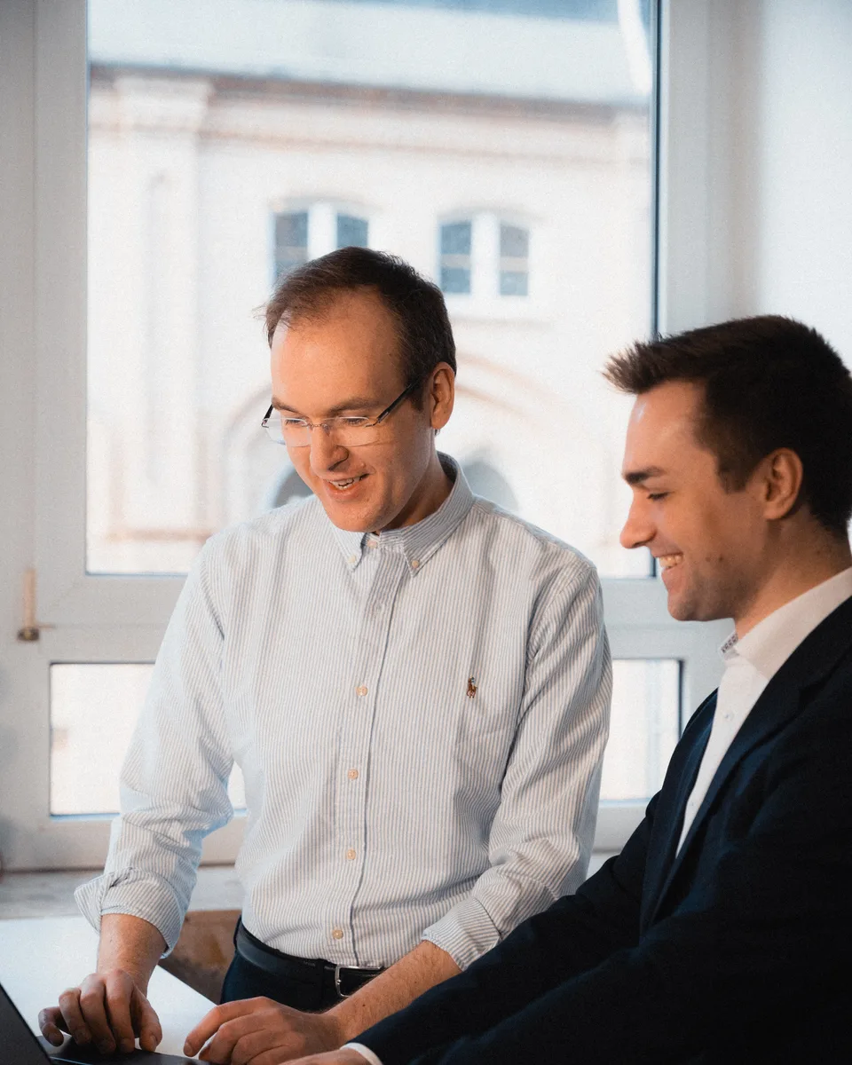 Zwei Mitarbeitende von Legal Data Technology besprechen gemeinsam eine Funktion am Laptop